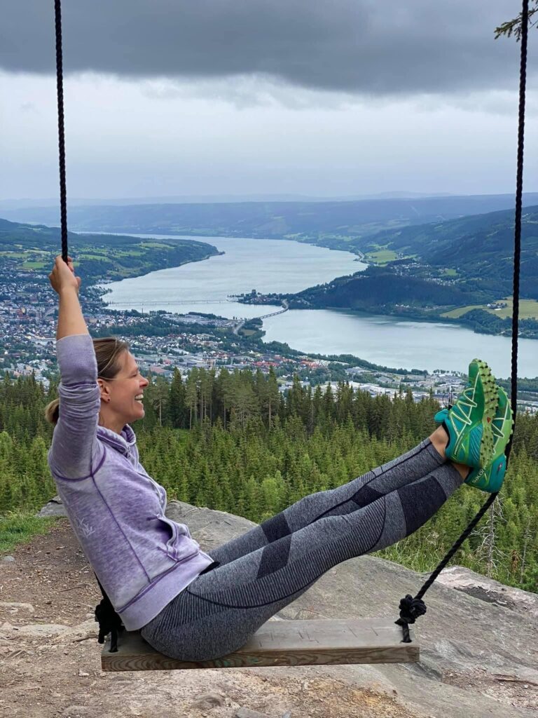 Andrea auf einer Schaukel hoch über einem Fjord in Norwegen